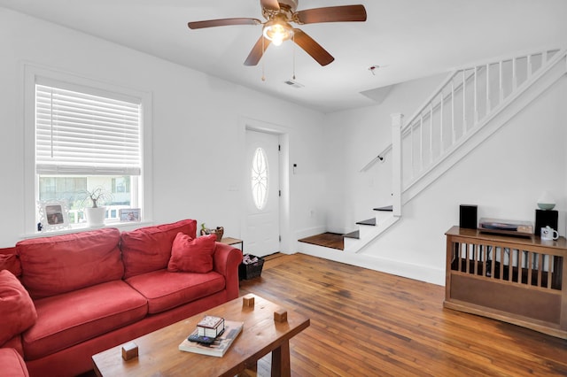 living room featuring stairs, hardwood / wood-style floors, healthy amount of natural light, and ceiling fan