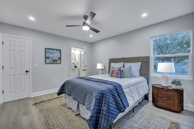 bedroom featuring recessed lighting, wood finished floors, a ceiling fan, baseboards, and ensuite bath