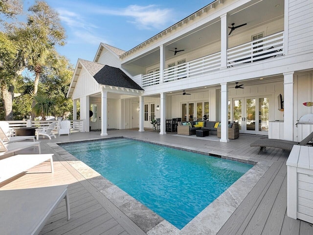 outdoor pool featuring an outdoor hangout area, french doors, a ceiling fan, and a deck