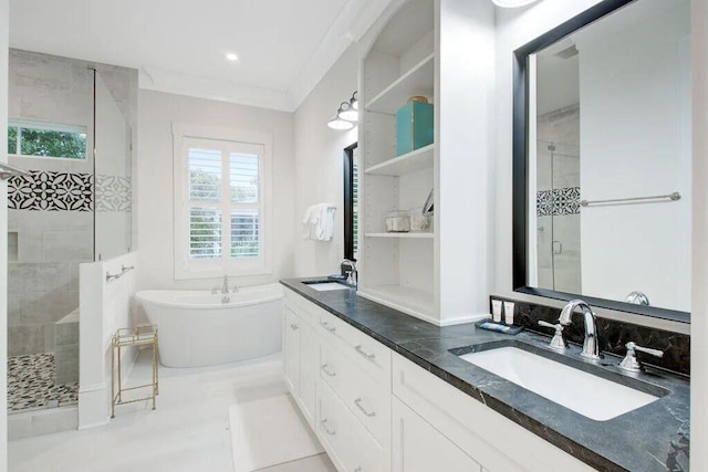 full bathroom featuring double vanity, a freestanding tub, a shower stall, and a sink