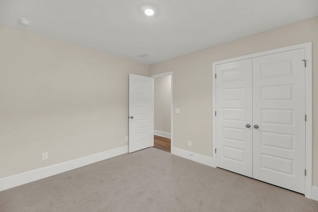 unfurnished bedroom with carpet flooring and a closet