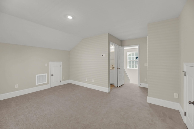 additional living space featuring light carpet and lofted ceiling