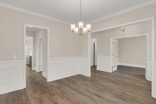 unfurnished dining area with dark hardwood / wood-style flooring, ornamental molding, and a chandelier