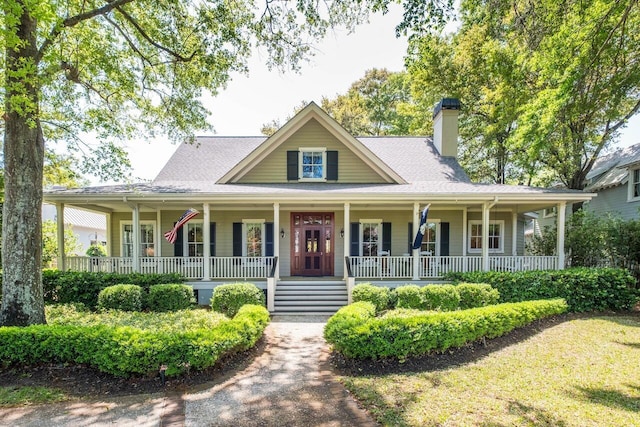 707 Royall Ave, Mount Pleasant, SC 29464 - farmhouse inspired home featuring a porch, roof with shingles, and a chimney