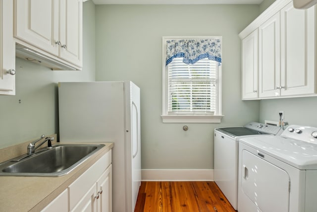707 Royall Ave, Mount Pleasant, SC 29464 - laundry area featuring baseboards, washer and dryer, a sink, wood finished floors, and cabinet space