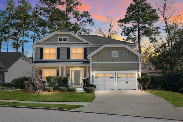 craftsman house featuring a porch, a garage, and a lawn