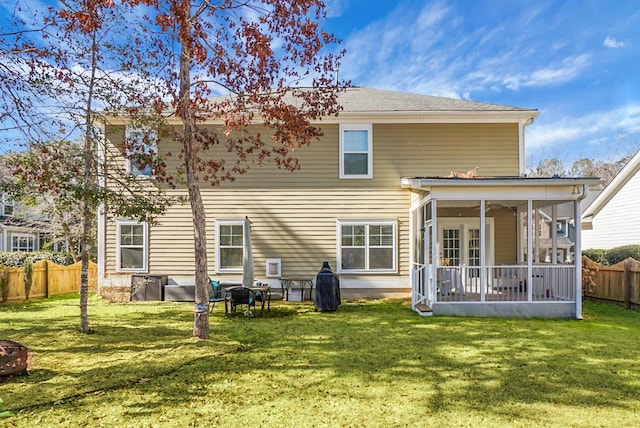 back of house with a lawn and a sunroom