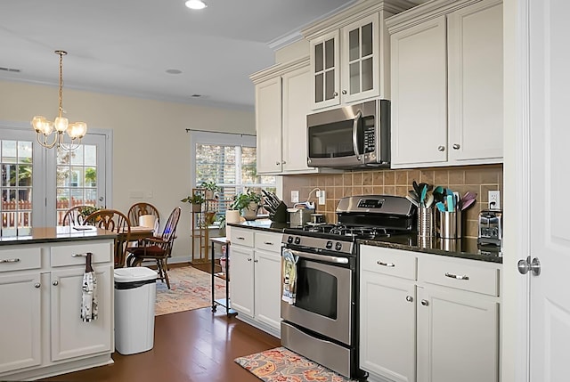 kitchen featuring stainless steel appliances, dark hardwood / wood-style flooring, decorative light fixtures, a chandelier, and decorative backsplash