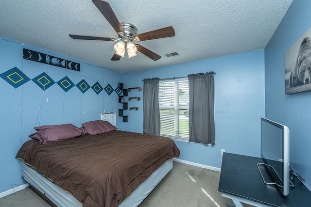 carpeted bedroom with ceiling fan and a textured ceiling