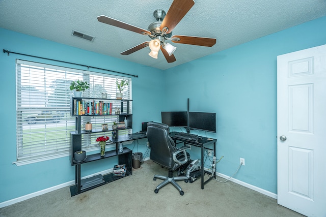 carpeted office space featuring a textured ceiling and ceiling fan