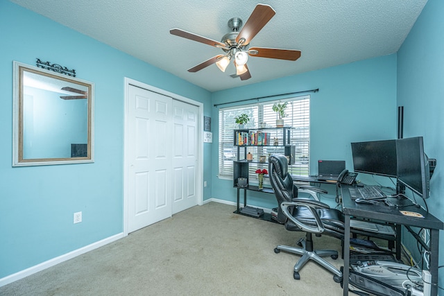 office area with a textured ceiling, light colored carpet, and ceiling fan