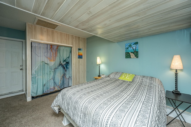 bedroom featuring wooden walls, a closet, carpet floors, and wooden ceiling