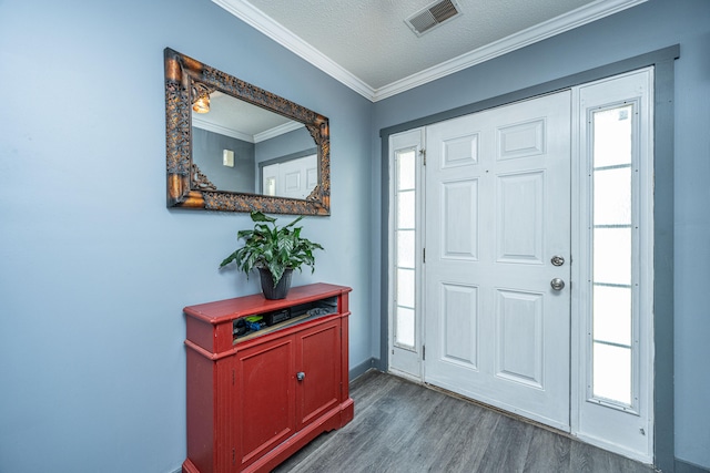 entrance foyer featuring a textured ceiling, dark hardwood / wood-style floors, a wealth of natural light, and ornamental molding