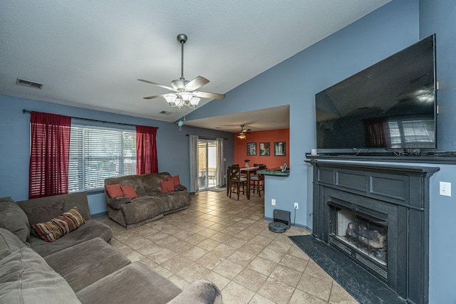 tiled living room with a textured ceiling, ceiling fan, and vaulted ceiling