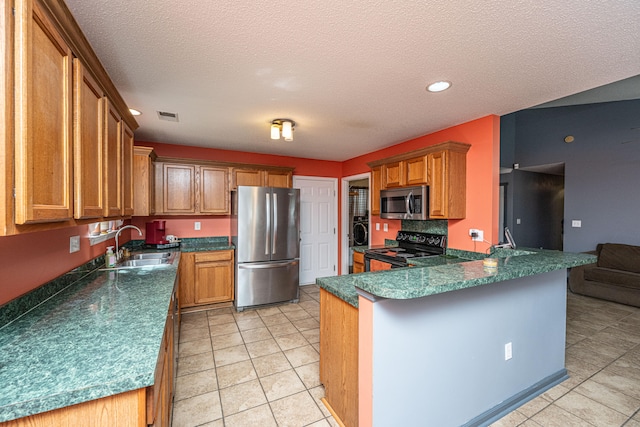 kitchen with sink, stainless steel appliances, kitchen peninsula, a textured ceiling, and light tile patterned floors