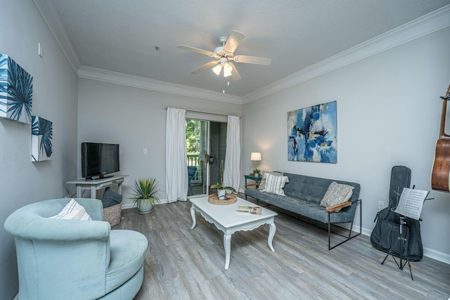 living room featuring ornamental molding, light wood-type flooring, and ceiling fan