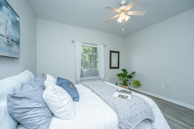 bedroom with a textured ceiling, hardwood / wood-style flooring, and ceiling fan