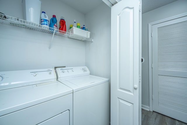 laundry room with independent washer and dryer, wood-type flooring, and a textured ceiling