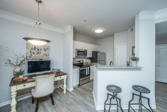 kitchen featuring appliances with stainless steel finishes, kitchen peninsula, light wood-type flooring, and white cabinetry