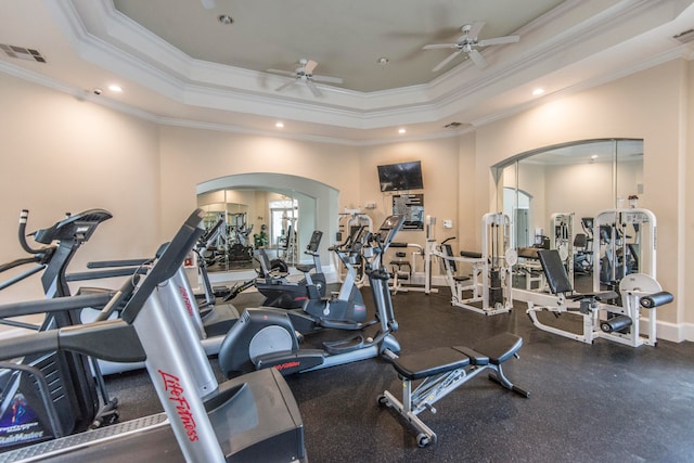 gym with ornamental molding, a tray ceiling, and ceiling fan