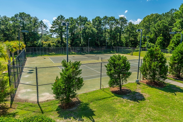 view of tennis court with a yard