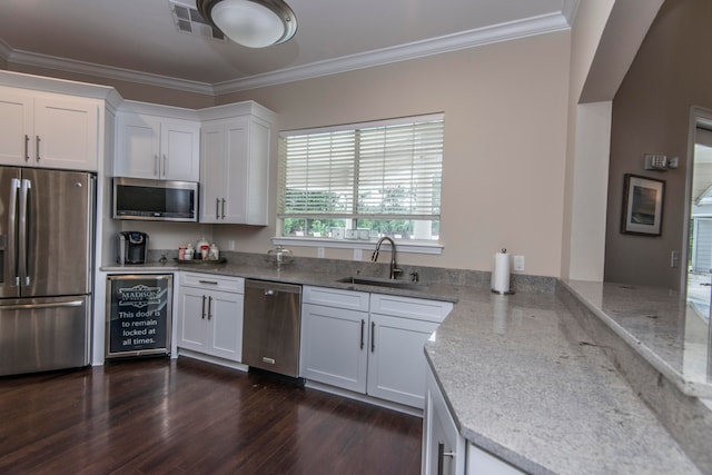 kitchen with appliances with stainless steel finishes, white cabinetry, sink, and dark hardwood / wood-style floors