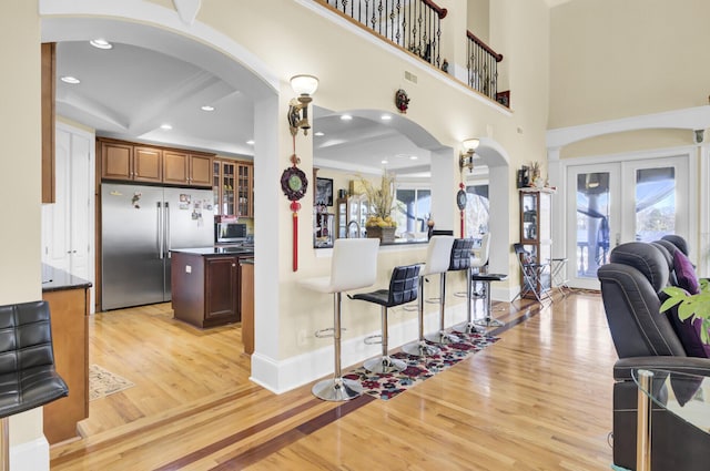 kitchen featuring stainless steel appliances, arched walkways, dark countertops, and a healthy amount of sunlight