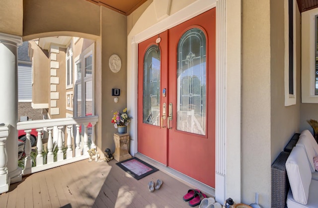 view of exterior entry featuring covered porch and stucco siding