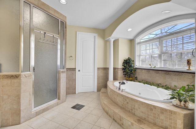 full bath featuring ornate columns, a whirlpool tub, a shower stall, tile patterned floors, and tile walls