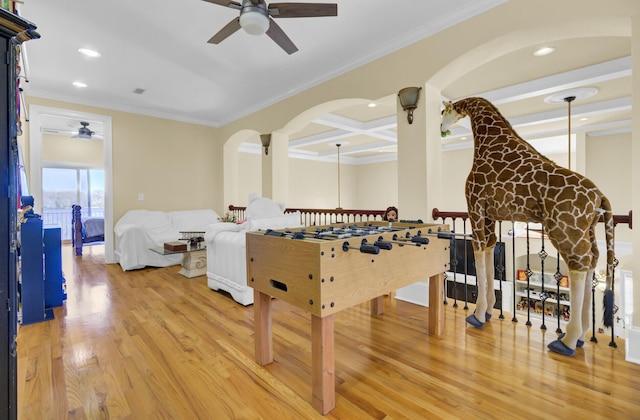 playroom featuring arched walkways, light wood-style floors, a ceiling fan, and coffered ceiling