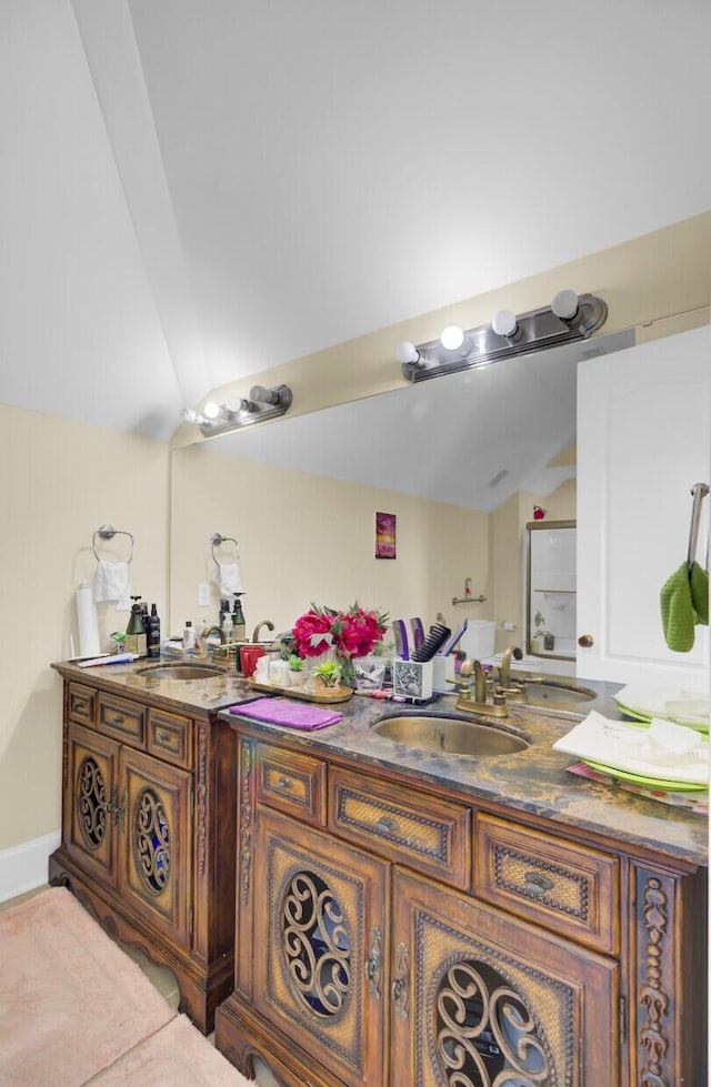 bathroom featuring vanity and lofted ceiling
