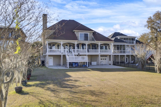 back of property with stairway, covered porch, a chimney, and a yard