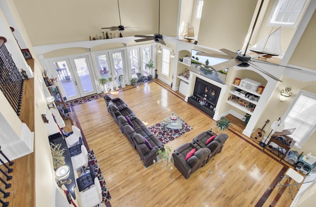 living room with visible vents, a ceiling fan, wood finished floors, french doors, and a high ceiling