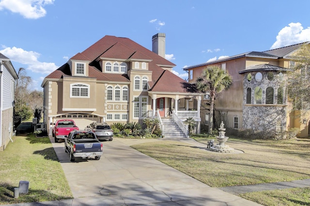 view of front of property with stucco siding, a front lawn, concrete driveway, an attached garage, and a chimney