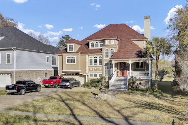 view of front of home featuring stucco siding, driveway, a porch, a garage, and a chimney
