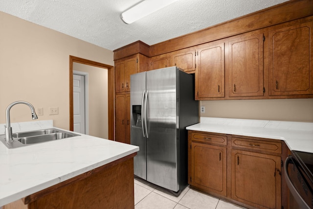 8116 Long Shadow Ln, North Charleston, SC 29406 - kitchen featuring stainless steel refrigerator with ice dispenser, stove, brown cabinetry, light countertops, and a textured ceiling