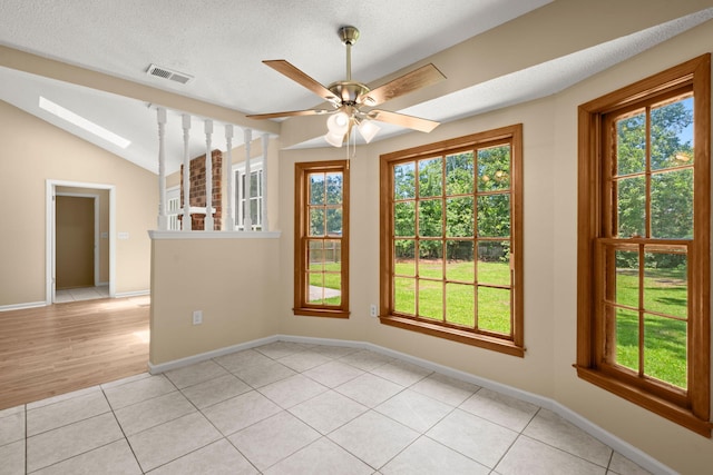 8116 Long Shadow Ln, North Charleston, SC 29406 - spare room with a skylight, plenty of natural light, light tile patterned floors, vaulted ceiling, and a textured ceiling