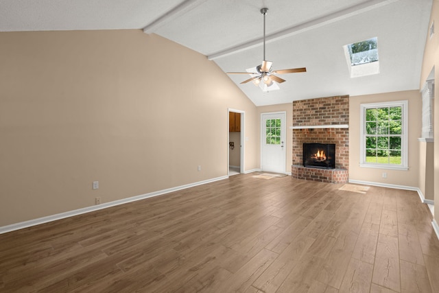 8116 Long Shadow Ln, North Charleston, SC 29406 - unfurnished living room with a ceiling fan, beamed ceiling, wood finished floors, a brick fireplace, and plenty of natural light