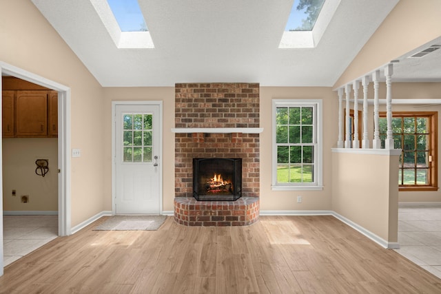 8116 Long Shadow Ln, North Charleston, SC 29406 - unfurnished living room with a skylight, lofted ceiling, wood finished floors, a brick fireplace, and plenty of natural light