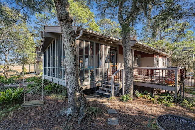 520 E Huron Ave, Folly Beach, SC 29439 - rear view of house with a sunroom and a wooden deck