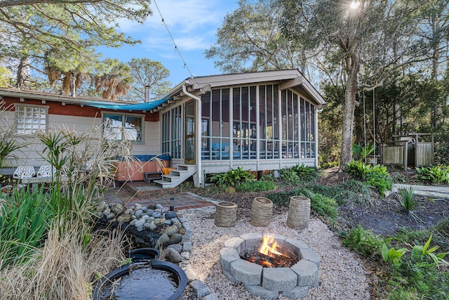 520 E Huron Ave, Folly Beach, SC 29439 - back of house featuring a sunroom, a hot tub, an outdoor fire pit, and a patio area