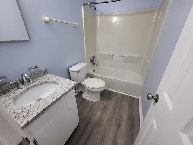 full bathroom featuring bathing tub / shower combination, toilet, vanity, and hardwood / wood-style flooring