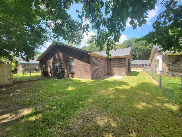 view of side of home featuring a lawn and central AC unit