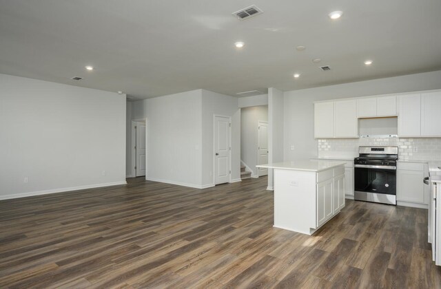 kitchen featuring a kitchen island, stainless steel range oven, dark hardwood / wood-style flooring, and white cabinetry