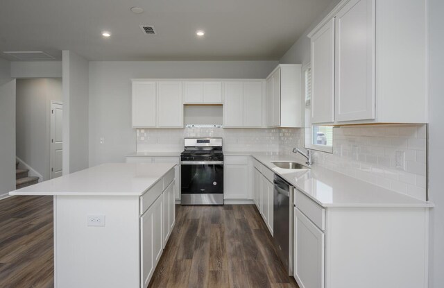 kitchen with a kitchen island, dark wood-type flooring, sink, white cabinetry, and appliances with stainless steel finishes