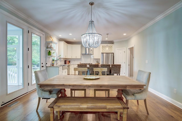 1976 Liberia Rd, Wadmalaw Island, SC 29487 - dining area with plenty of natural light, a chandelier, wood-type flooring, ornamental molding, and recessed lighting