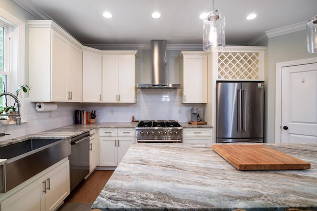 1976 Liberia Rd, Wadmalaw Island, SC 29487 - kitchen featuring premium appliances, wall chimney exhaust hood, crown molding, a sink, and light stone counters