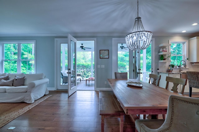 1976 Liberia Rd, Wadmalaw Island, SC 29487 - dining area featuring french doors, baseboards, a chandelier, dark wood-type flooring, and crown molding