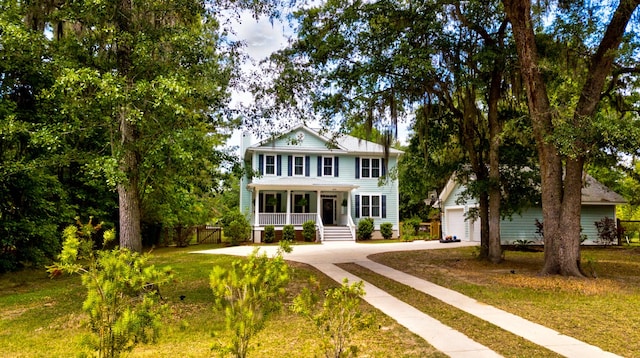1976 Liberia Rd, Wadmalaw Island, SC 29487 - view of front of home featuring concrete driveway, covered porch, fence, and an outdoor structure