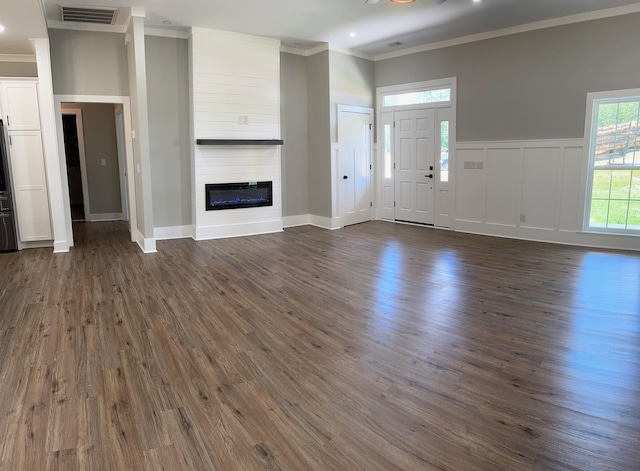 unfurnished living room featuring ornamental molding, a fireplace, and dark wood-type flooring